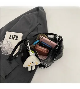 Top view of spacious black tote bag interior with silver chain and plush charm