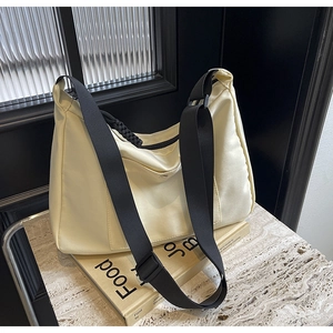 Dettaglio della borsa a mezzaluna in nylon bianco sporco con tracolla nera