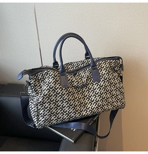 Detail of blue leather handles and jacquard fabric on a large capacity travel tote bag