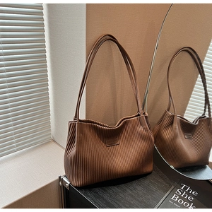 Detailed view of the brown leather tote bag with pleated texture and fashion logo