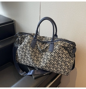 Detail of large travel tote featuring geometric chain pattern and navy leather straps