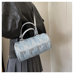 Detail of vintage denim boston bag with silver sequins shown on female model