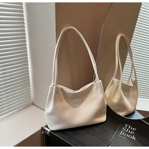 Close-up of cream corduroy tote bag texture with fashion label and mirror reflection