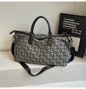 Detail of travel tote bag with black and white geometric pattern on marble surface