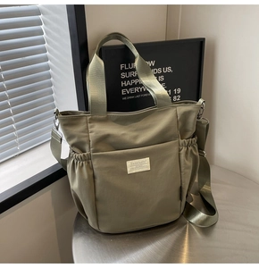 Detail of Morandi green waterproof nylon tote bag with adjustable woven strap and side pocket