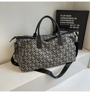 Detail of travel tote bag featuring U-shaped jacquard pattern and leather handles