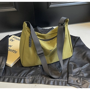 Dettaglio della borsa tote in nylon verde oliva con tracolla regolabile e tasca frontale