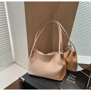 Detailed shot of pleated apricot tote bag with Fashion & Bags leather label and thin straps