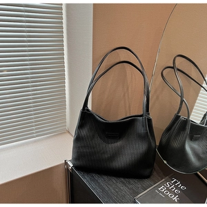 Close-up of black vertical pleated tote bag with fine textures and branding detail