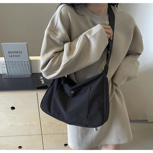 Dettaglio borsa tote in nylon nero con tasca a scatto e trama impermeabile resistente