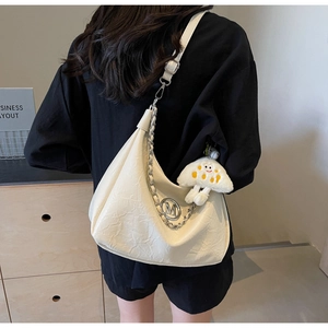 Detail of cream pleated crescent bag with silver chain and cute cloud plush pendant
