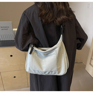 Dettaglio della borsa tote in nylon celeste con tasca a bottone e tracolla regolabile