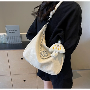 Detail of off-white pleated tote bag with silver M logo and plush mushroom charm