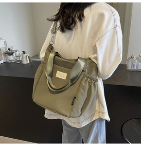Olive green waterproof nylon crossbody bag shown in a lifestyle indoor setting