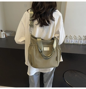 Olive green nylon crossbody tote bag showing large capacity and drawstring pocket