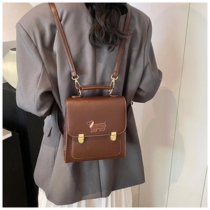Detailed back view of a brown leather backpack with dachshund embroidery and gold hardware