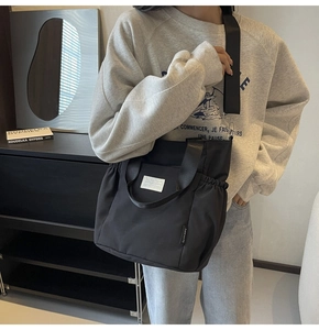 Lifestyle shot of a black waterproof nylon crossbody bag with stylish ruched side details