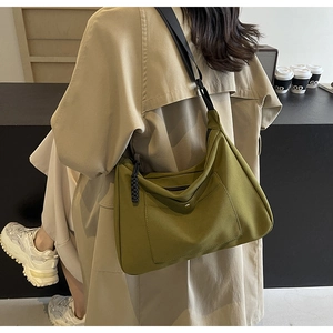 Dettaglio della borsa tote in nylon verde oliva con tasca a scatto e tiranti intrecciati