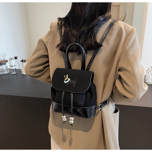 Detail eines schwarzen Mini-Rucksacks mit Dackel-Stickerei und glänzendem Lederboden-Element