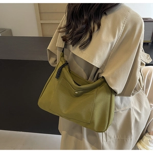 Dettaglio della borsa tote in nylon verde con tasca a fibbia e tirazip in tessuto