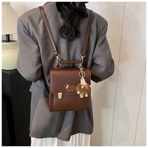 Rear view of brown retro backpack with dachshund embroidery and plush charm