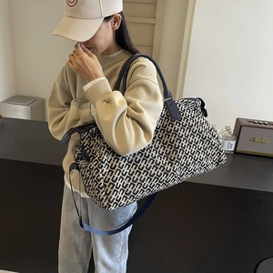 High-capacity travel tote bag with black and white geometric pattern and shoulder strap