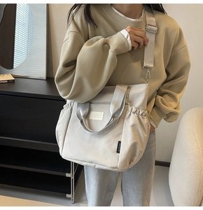 Detail of light beige waterproof nylon tote bag with drawstring texture and adjustable strap