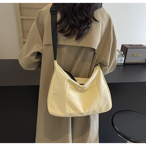 Vista posteriore di una borsa tote in tela beige con tasca frontale e tracolla