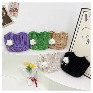 Detailed close-up of colorful crochet tote bags with plush cloud charms and woven texture