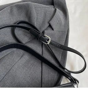 Détail de la bandoulière réglable en cuir Saffiano noir avec boucle en métal argenté