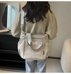 Detail of waterproof nylon shoulder bag with adjustable strap and drawstring side pocket