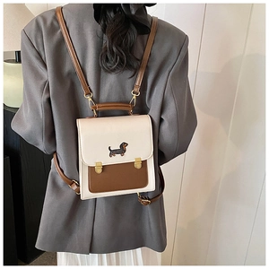 Detailed back view of model wearing a vintage-style cream and brown embroidered backpack