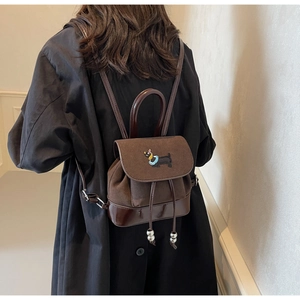 Detail eines Vintage-Mini-Rucksacks aus mattem Wildleder mit bunter Dackel-Stickerei