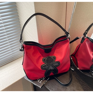 Détail du sac de voyage rouge avec ours en paillettes noires et bandoulière réglable
