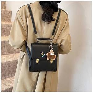 Detail of black PU leather backpack with gold metal clasp and cat embroidery