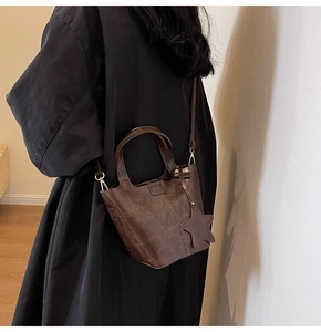 Détail du sac seau marron vintage avec pendentif étoile et crochet en métal doré