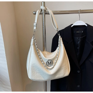 Detail of cream white pleated hobo bag with silver M logo and metal chain strap