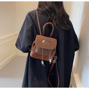 Detail eines braunen Vintage-Wildlederrucksacks mit Dackelstickerei und Kordelzug