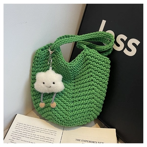 Detail of green knitted bucket bag featuring woven texture and a cute cloud charm