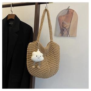 Detail of beige hand-woven shoulder bag with thick knit texture and cloud charm