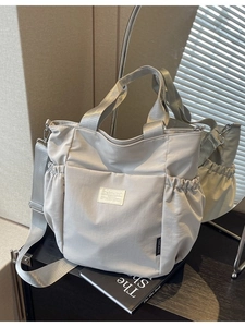 Waterproof light grey nylon shoulder bag with adjustable strap and side drawstring pockets