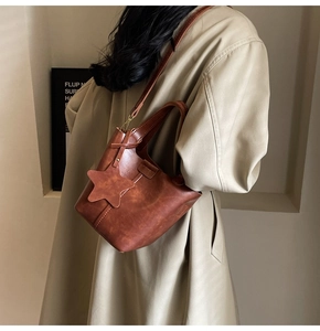 Détail du sac seau en cuir PU marron caramel avec breloque étoile et bandoulière