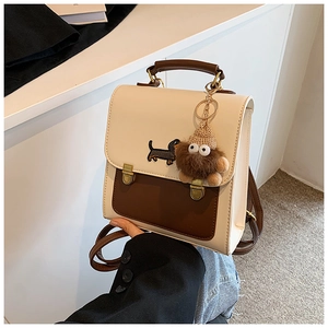 Detail of retro cream and brown contrast backpack with dachshund print and plush charm