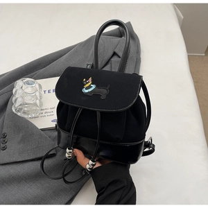Details der Dackeleinstickerei und Materialmix auf schwarzem Kordelzugrucksack