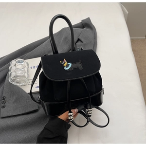 Detail eines schwarzen Mini-Rucksacks mit Dackel-Stickerei und silbernen Kordelzügen