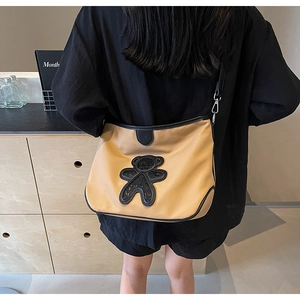 Détail du sac de voyage en nylon kaki avec ours en paillettes noires porté au dos