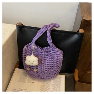 Detailed close-up of a purple hand-woven crochet tote bag with a white cloud plush charm