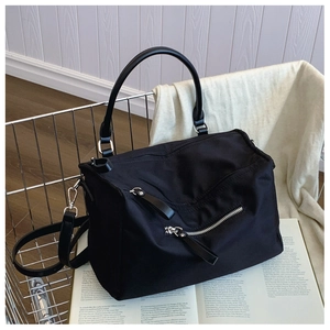 Detail of black nylon crossbody bag with leather handles in a shopping cart