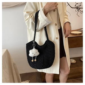 Detail of black woven knit tote bag with plush cloud charm and sturdy braided handles