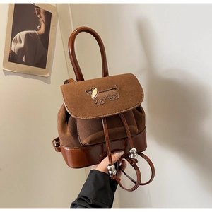 Detail eines braunen Vintage-Rucksacks mit Dackel-Stickerei und Kordelzugverschluss